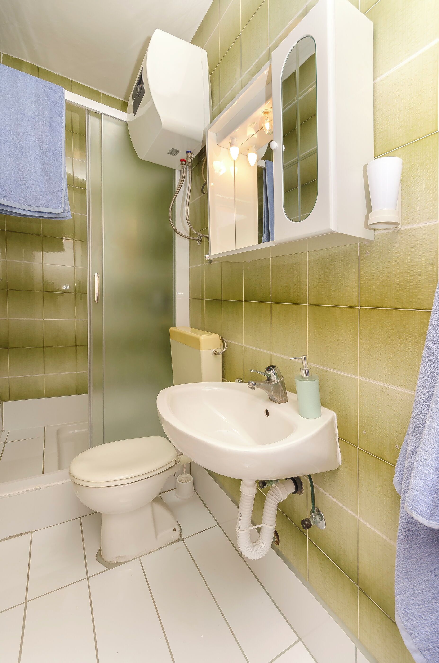 A bathroom with a toilet, sink, and shower.