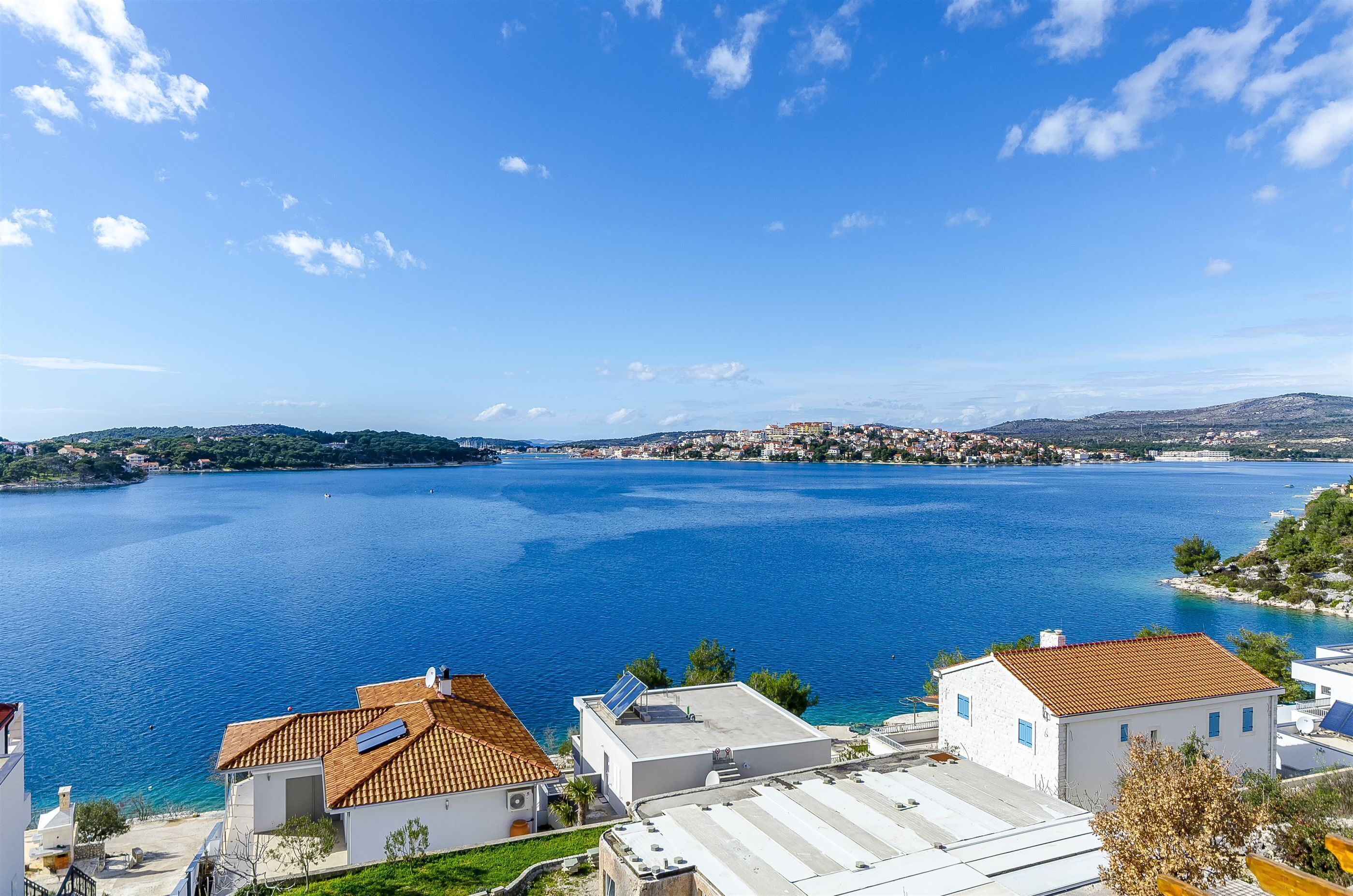 A coastal town with buildings near a large body of water, likely a bay or sea.
