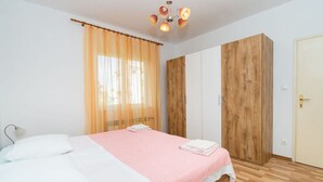 Ein Schlafzimmer mit Bett, Schrank und Tür.