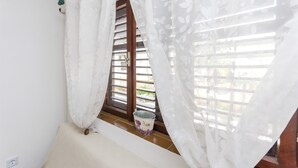 A window with white curtains, a wooden shutter, and a bucket on the sill. - Apartment Sandra (Vodice)