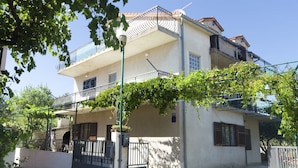 A two-story building with a balcony, a gate, and a street view. - Apartment Sandra (Vodice)