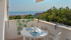 A balcony with a table, chairs, and a view of the sea. - Apartments Family Gligora (Mandre)