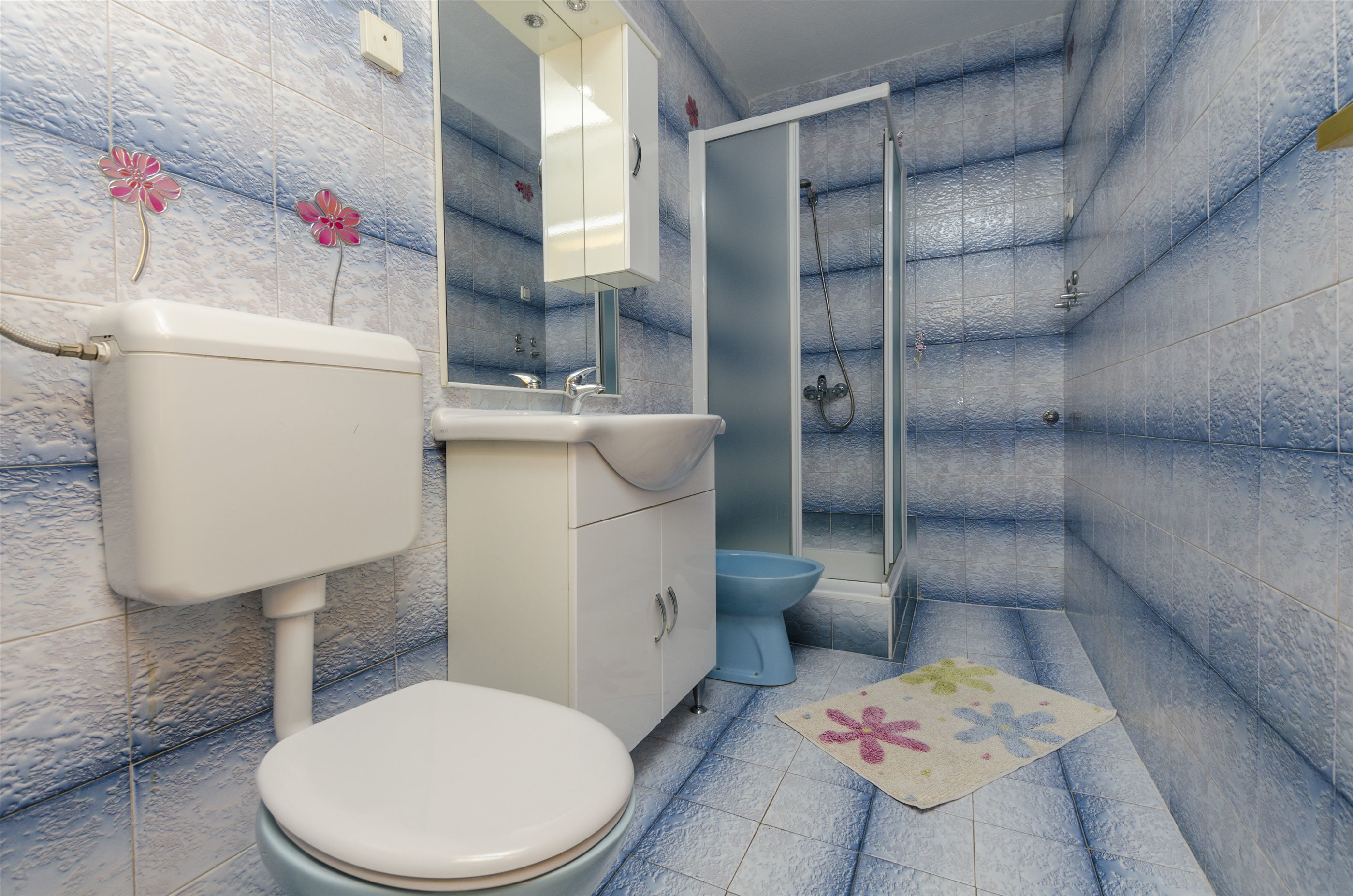 A bathroom with a toilet, sink, and shower.