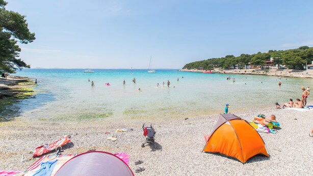 A beach with tents, people, and boats. - Apartments Emil (Murter)