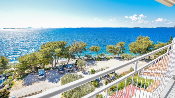Un balcon avec vue sur une plage et la mer.