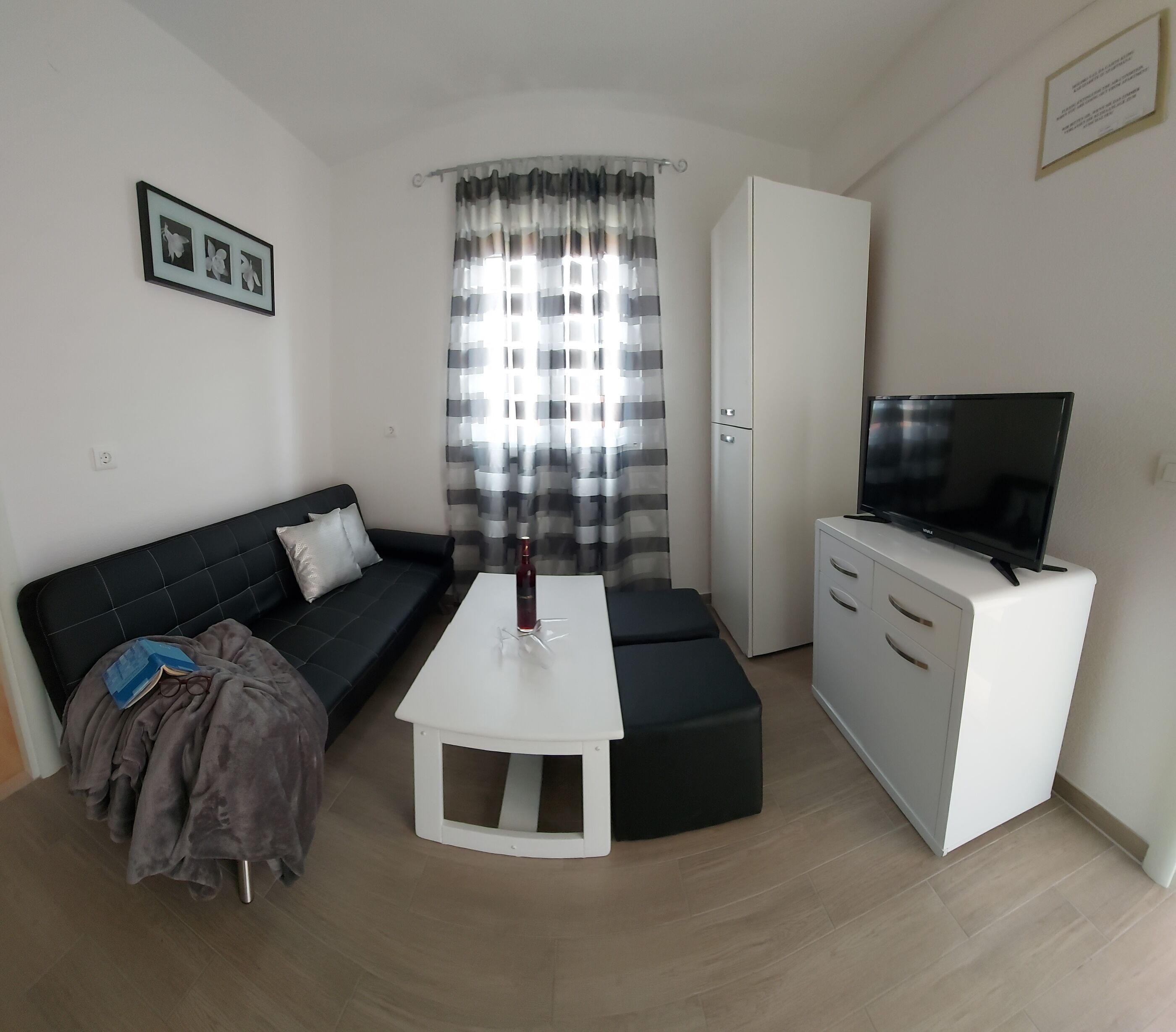 Un salon moderne comprenant un canapé, une table basse, un téléviseur et un meuble.