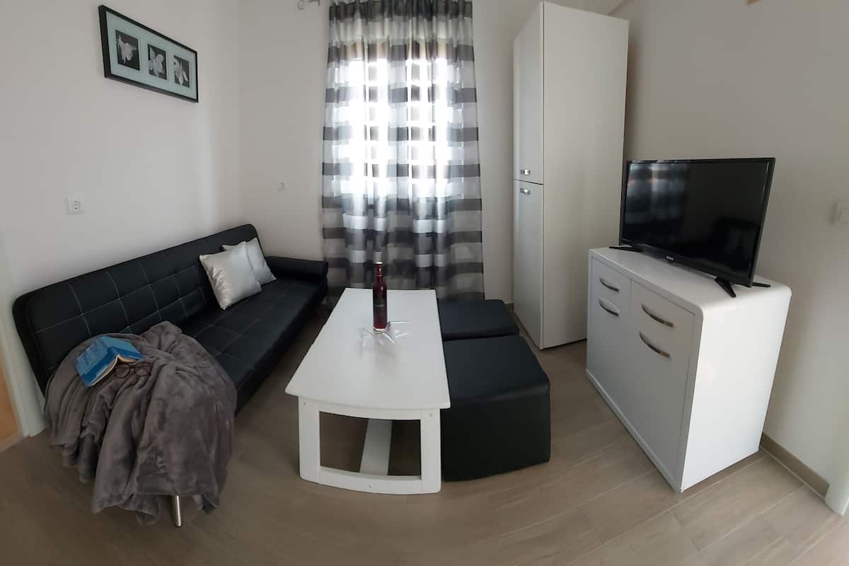 A modern living room with a sofa, a coffee table, a TV, and a cabinet.