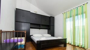 Una camera da letto con un letto, una testiera in legno, una scrivania e una sedia.