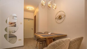 A dining area with a wooden table, cushioned chairs, and wall-mounted mirrors.