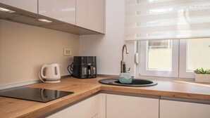 A modern kitchen with a built-in stove, a coffee maker, and a sink with a faucet.
