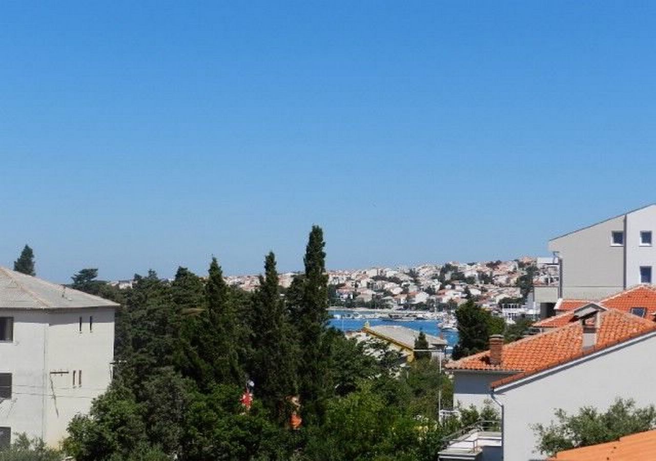 A coastal town with buildings, a clear sky, and a view of the sea.
