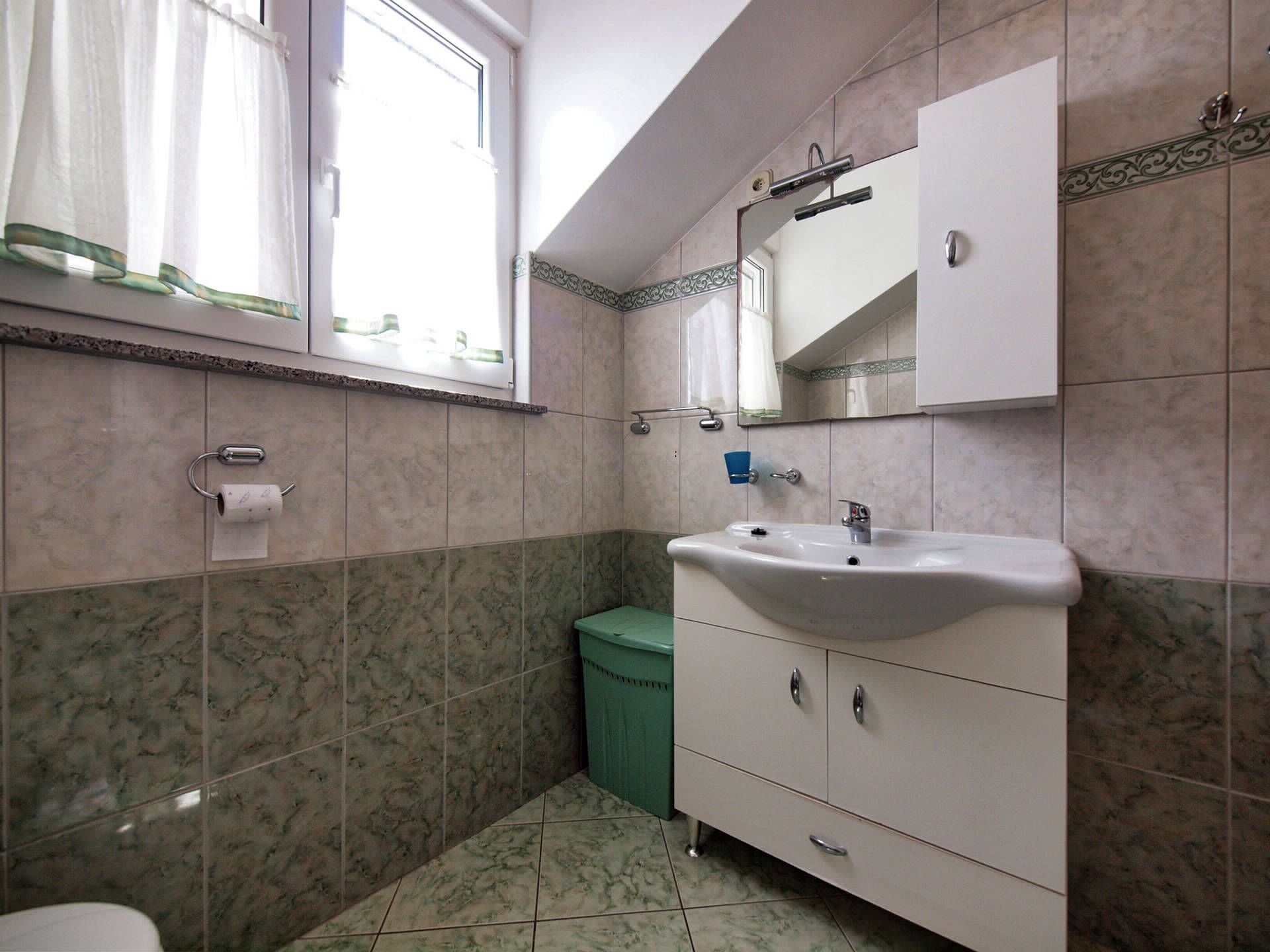 A bathroom with a sink, mirror, and toilet.