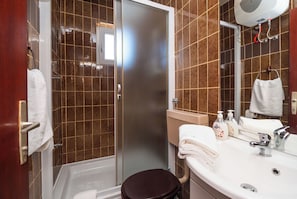 A bathroom with a shower, toilet, sink, and mirror. - Apartments Violett (Vodice)