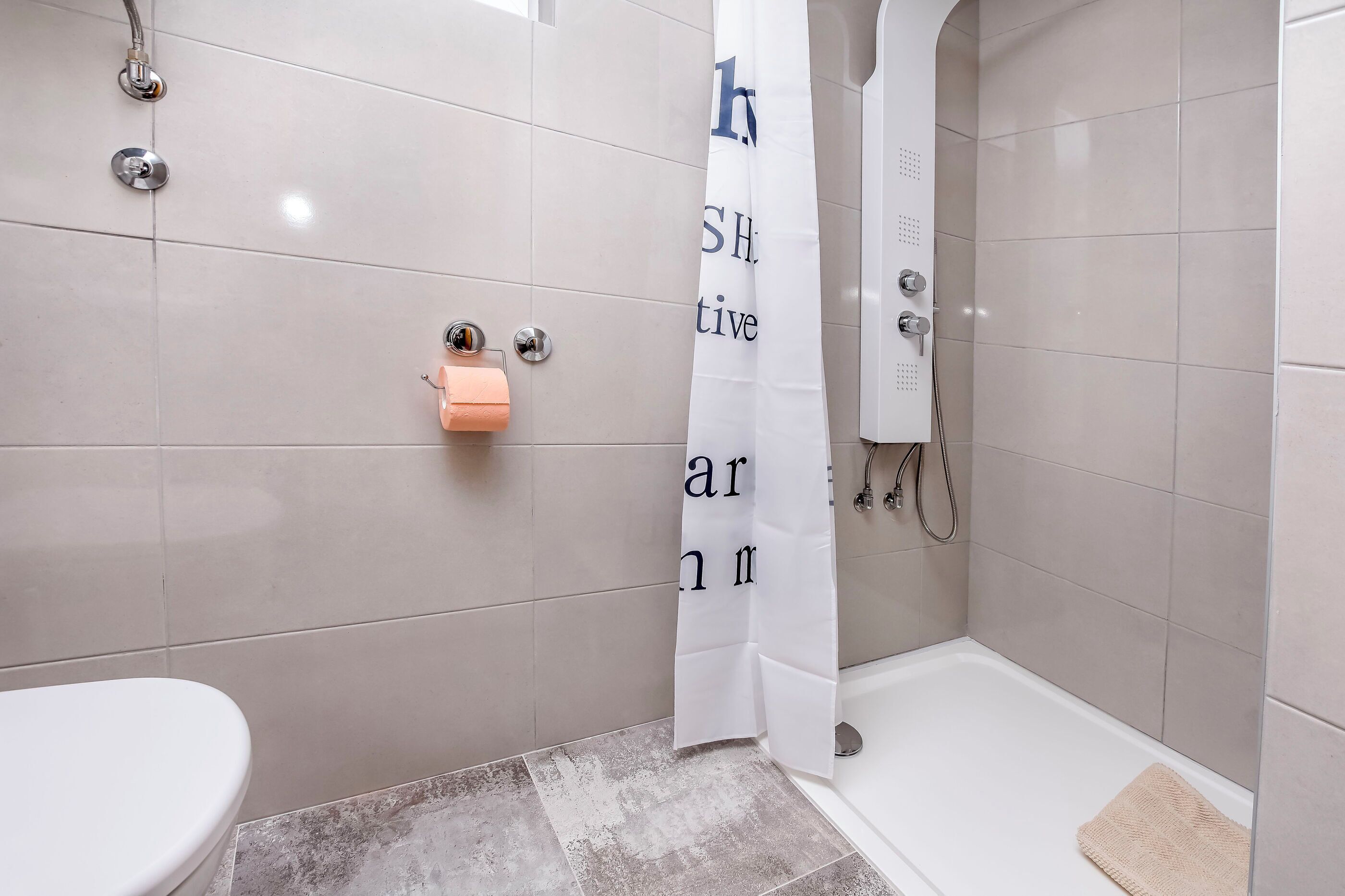 Ein Badezimmer mit Toilette, Dusche und Badewanne.