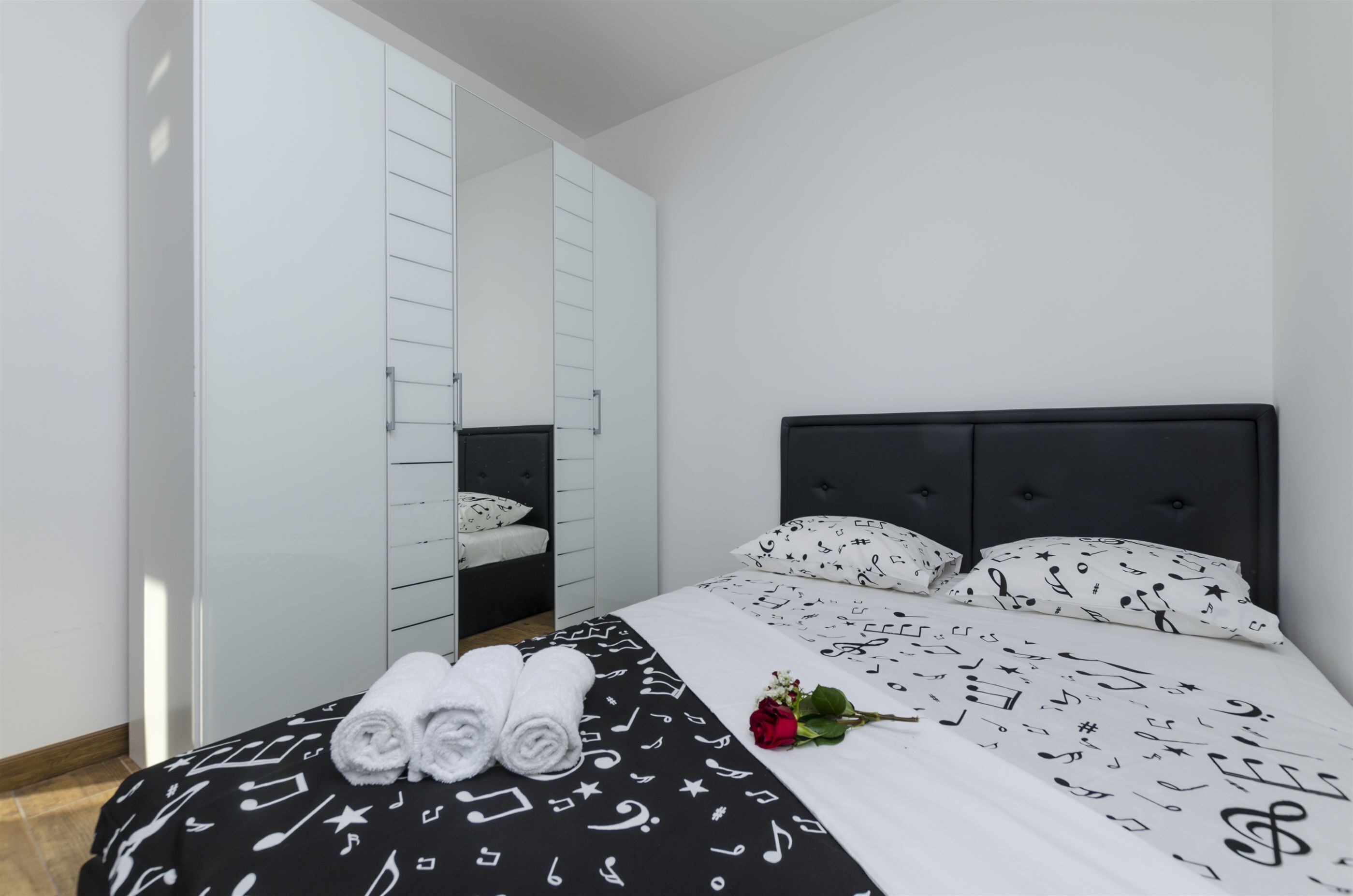Un dormitorio con cama, armario y espejo.