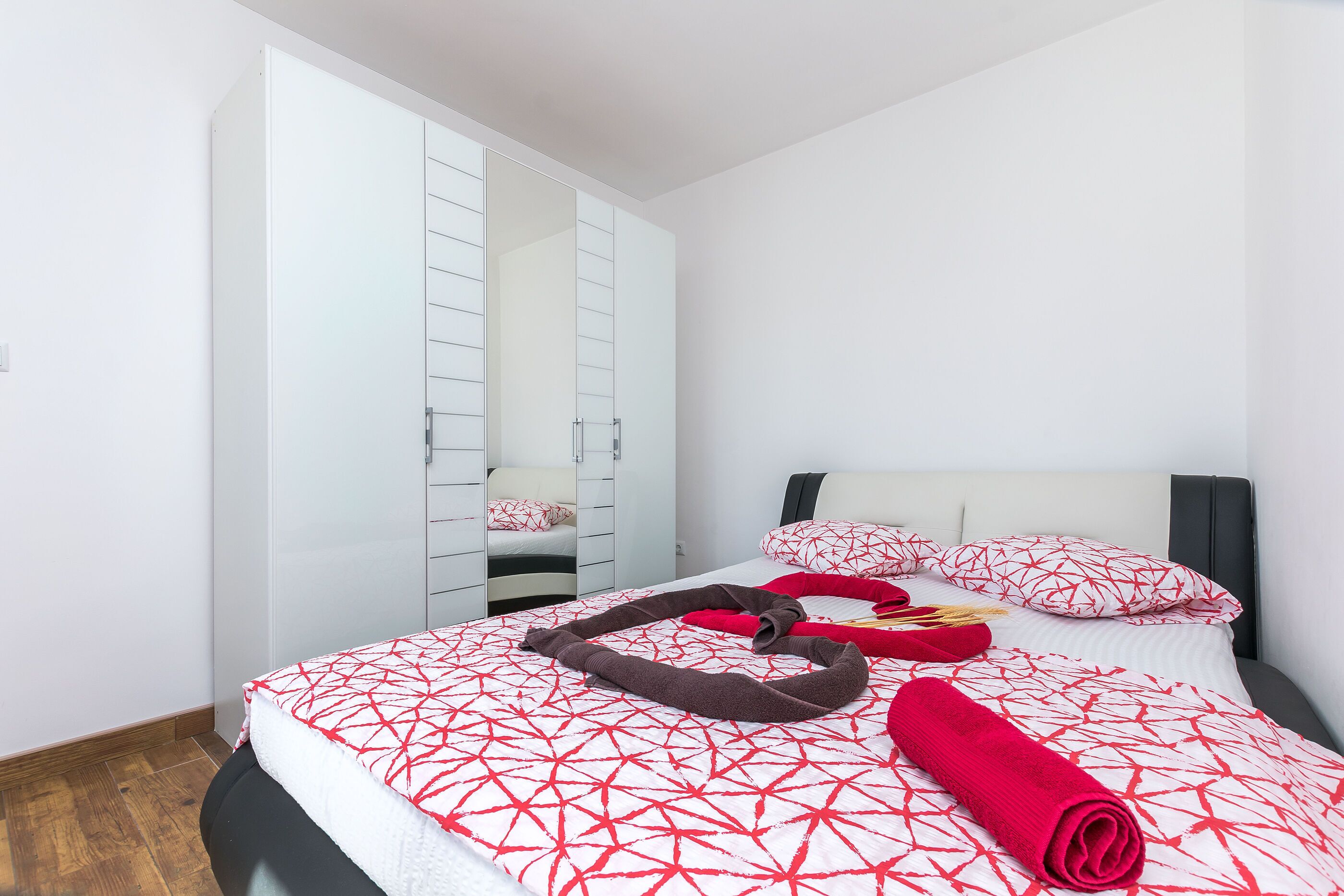 Ein Hotelzimmer mit Bett, Kleiderschrank und Spiegel.
