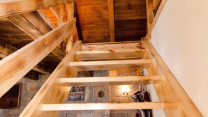 A wooden interior with a staircase, stone walls, and a fireplace. - House Radojka (Tisno)
