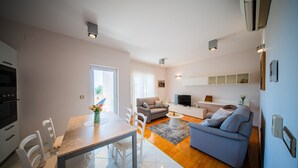 A modern apartment with a dining area, living room, and kitchen. - Apartments Dyana (Novalja)