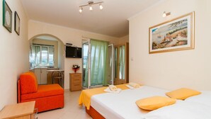 A hotel room with a bed, a desk, a chair, and a TV. - Apartments Ena (Pag)