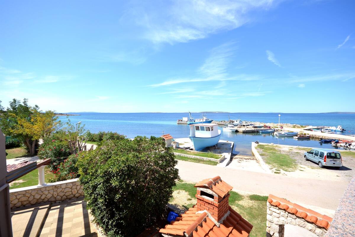 A coastal view with a marina, boats, and a van parked near the water.