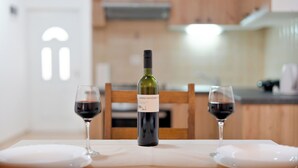 A bottle of wine on a table with two glasses of red wine. - Apartments Luka (Zubovici)