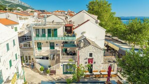 Ein Küstengebäude mit Balkon, einer Steinfassade und Blick aufs Meer.
