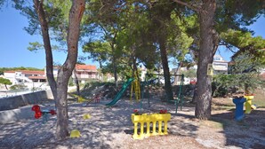 Un'area giochi con uno scivolo, altalene e una struttura per arrampicarsi.