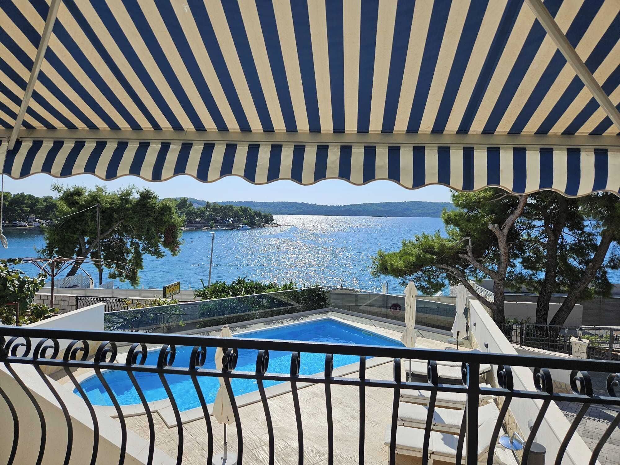 A pool area with a view of a lake and a distant island.