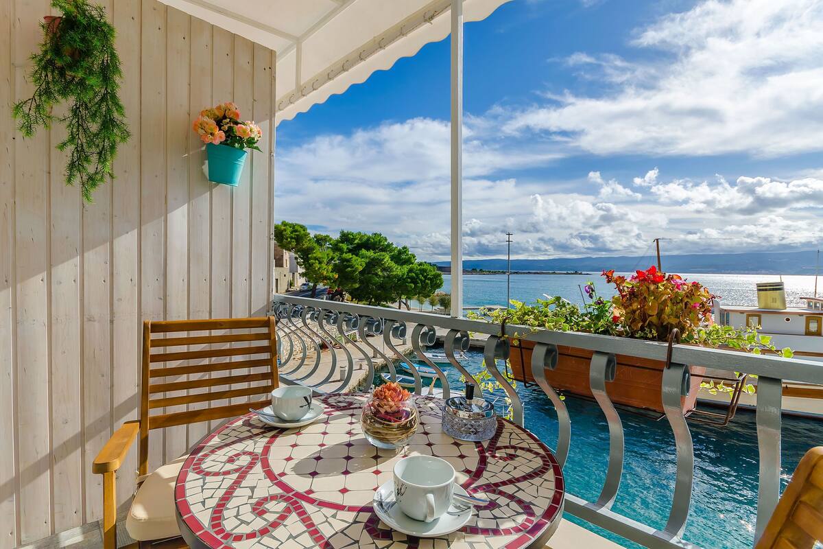 Ein Balkon mit einem Tisch für zwei Personen, einem Stuhl und Meerblick.