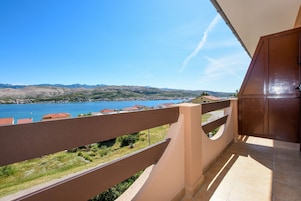 Un balcone con vista su un lago e delle montagne.