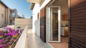 A residential building with a sliding glass door leading to a kitchen area. - Apartment Mijo (Vodice)