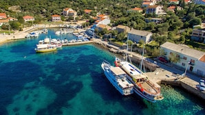 A coastal town with a marina, boats, and houses with red roofs. - Apartments Ivan Sea View Lun (Lun)