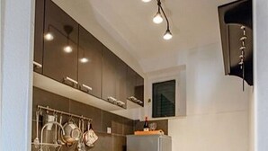 Una cocina moderna con armarios oscuros, encimera de madera y horno empotrado.