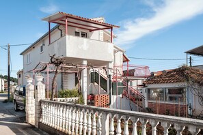 A two-story house with a balcony, a staircase, and a gated entrance. - Apartments Mala Dalmacija (Marina)