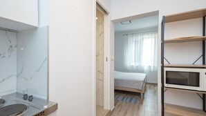 A modern kitchen with a marble backsplash and a microwave on a shelf. - Apartments Zecic (Omis)