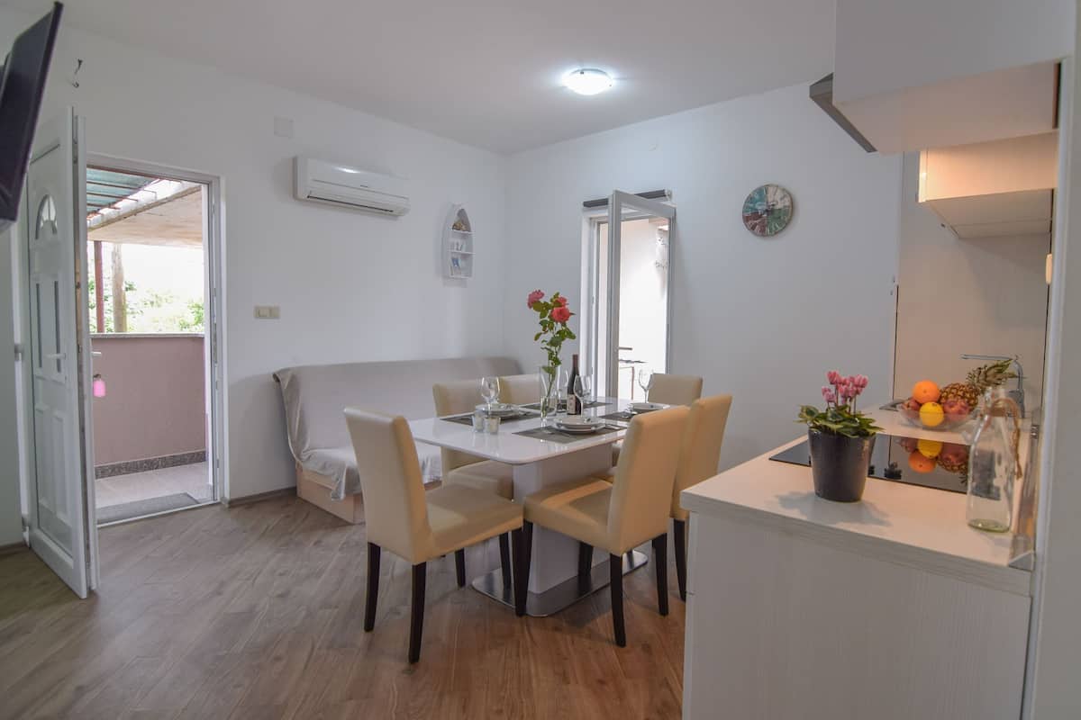 A dining area with a table set for four, surrounded by chairs.