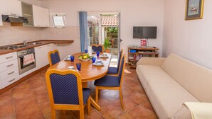 Un espacio habitable pequeño con cocina, comedor y sofá.