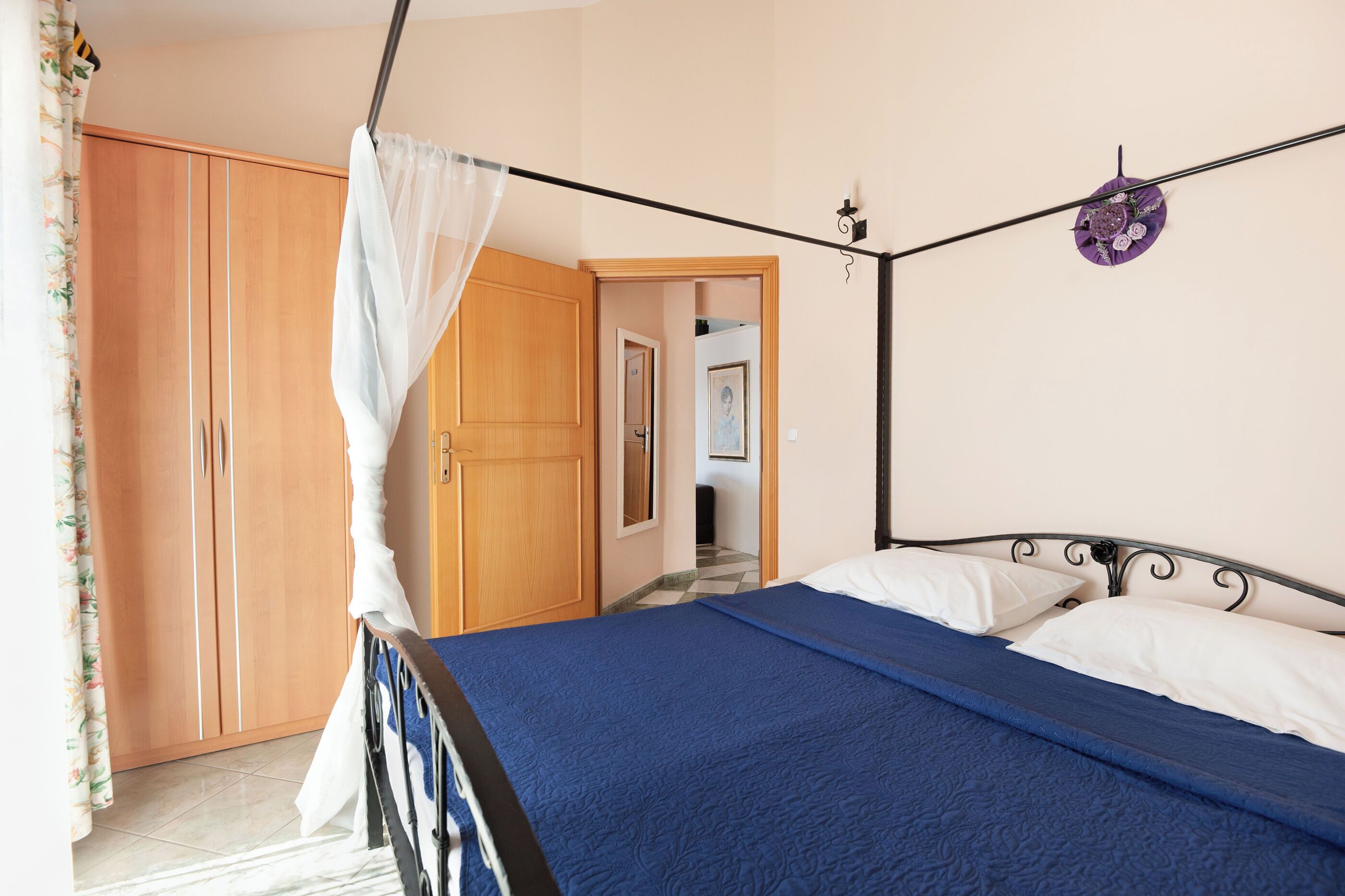 Une chambre à coucher avec un lit, une armoire et un rideau.