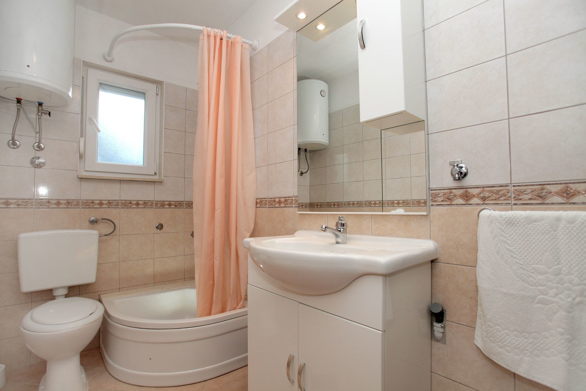 A bathroom with a toilet, sink, and bathtub.