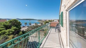 Un balcon offrant une vue sur une zone côtière, notamment une plage et la mer.