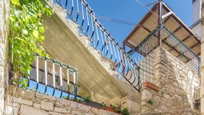 A stone building with a wooden door and a metal gate. - Apartments Islandbreeze (Prvic Sepurine)
