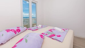 Una habitación con dos camas, cada una con ropa de cama y toallas estampadas con motivos florales.
