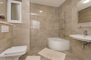 Un bagno moderno con il water, una vasca e un lavandino.