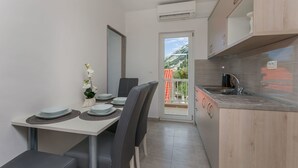 Una cocina compacta con comedor, vistas al exterior y un pequeño balcón.