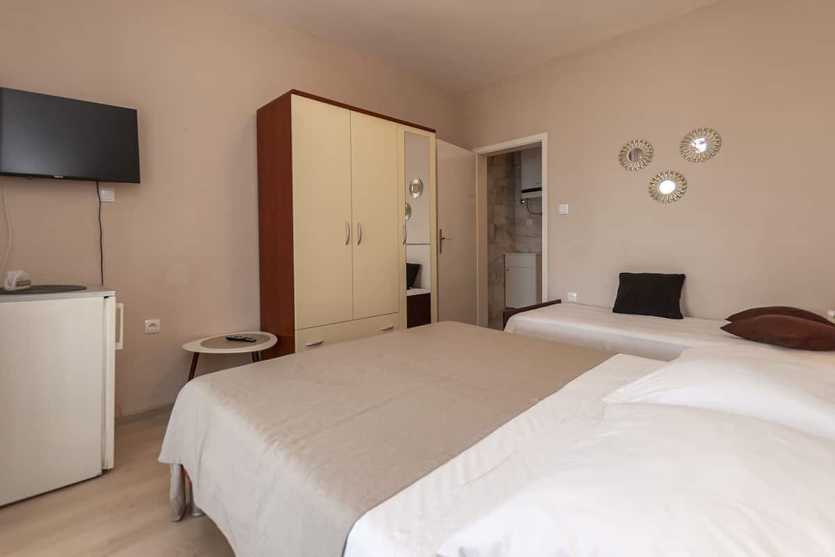 Une chambre d’hôtel équipée d’un lit, d’un bureau, d’une armoire et d’un téléviseur.