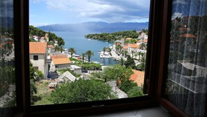A coastal town with buildings, boats, and mountains in the background. - Apartments Boro (Splitska)