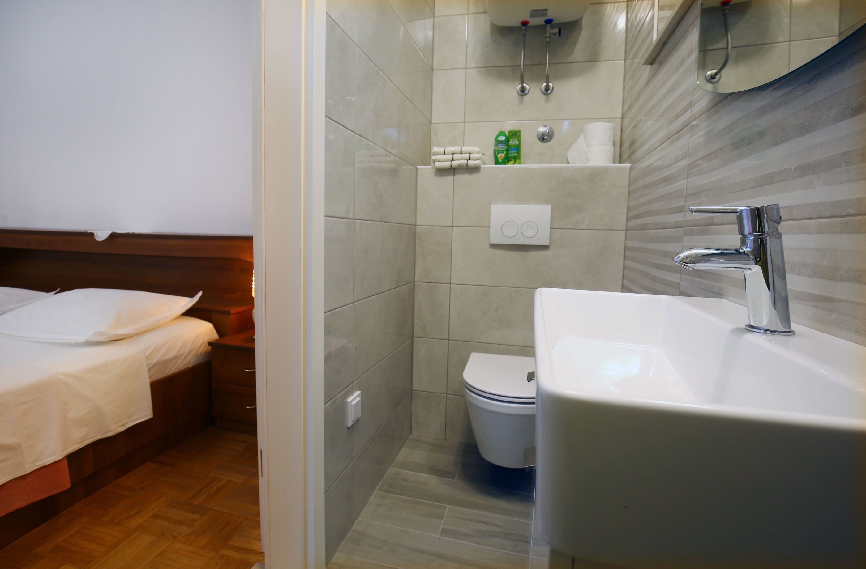 A compact hotel bathroom with a shower, toilet, and sink.