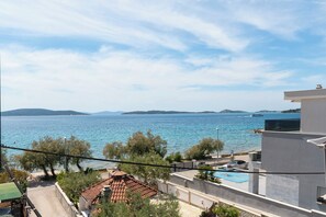 Une vue sur la côte, avec un ciel dégagé, une piscine et un bâtiment doté d’un toit plat.