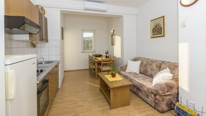 A compact living space with a kitchenette, a dining area, and a sofa.