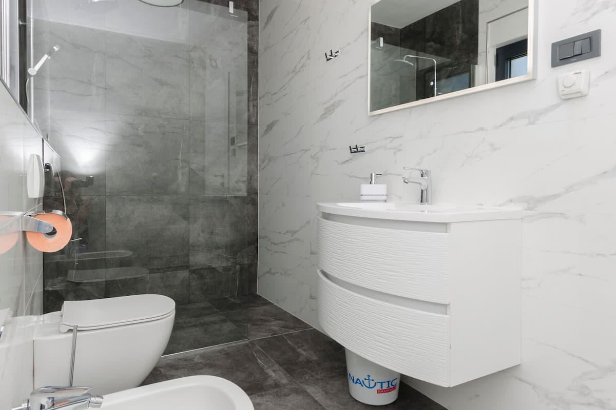 Un baño moderno con ducha, bidé y tocador.